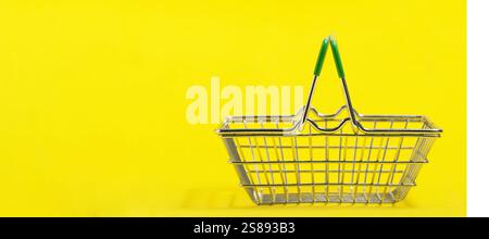 Empty shopping basket isolated on yellow background. Copy space for text Stock Photo