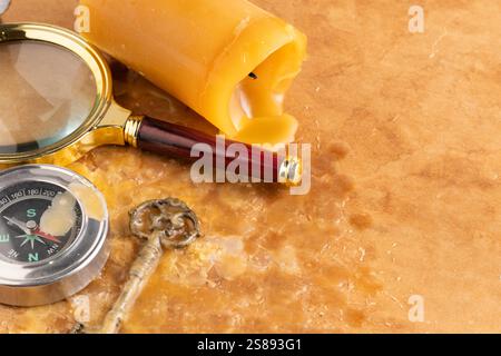 Old compass, magnifying glass and old key on paper background Stock Photo