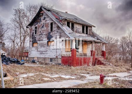 An old white house next to an empty lot in Highland Park that was damaged by fire has been abandoned and is gradually falling apart. Stock Photo