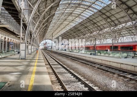 On the almost empty railroad platform at the Woodrow Wilson train station in Prague, a few anonymous travelers stand on the tracks. Stock Photo