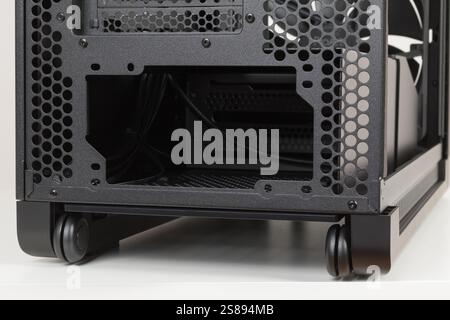 Back side of empty  big  tower computer case, chassis , effortless maneuvering with two built-in  wheels.  At the bottom is a place for  power supply Stock Photo