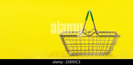 Empty shopping basket isolated on yellow background. Copy space for text Stock Photo
