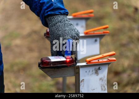 A woman punching at the orienteering start control point close up. Female in forest checking to a control point. Selective focus Stock Photo