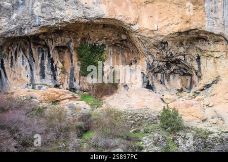 Caves on the rocky wall of the gorge of Guadalaviar river in Albarracin town, Spain Stock Photo