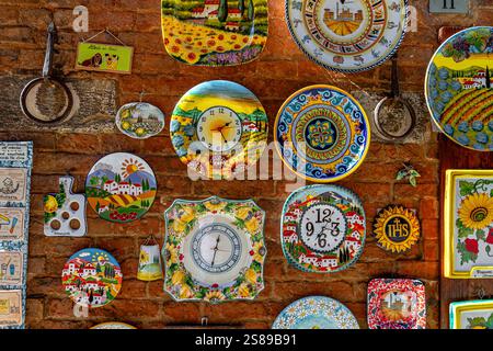 Brightly coloured decorative ceramic plates hanging on a wall in Siena ,Italy Stock Photo