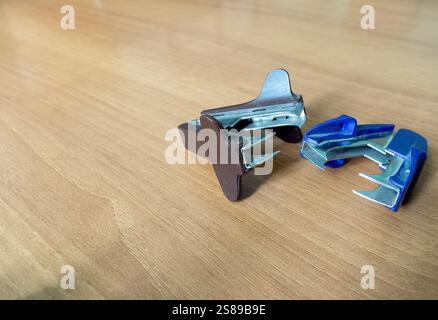 Stationery material. Staple opener. Staple remover. Blue background. Stock Photo