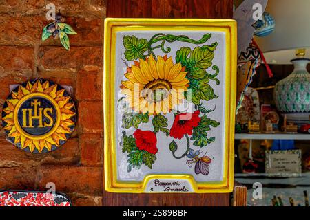 Brightly coloured decorative ceramic plates hanging on a wall in Siena ,Italy Stock Photo