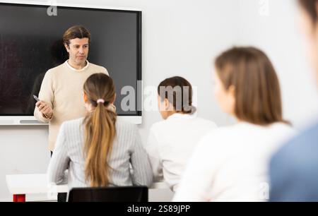 Experienced male teacher giving lecture to group of student Stock Photo
