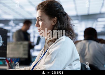 Computer scientist working in high tech server hub capable of processing vast amounts of data. Close up shot of woman at PC typing on keyboard, updating servers controlling network resources Stock Photo