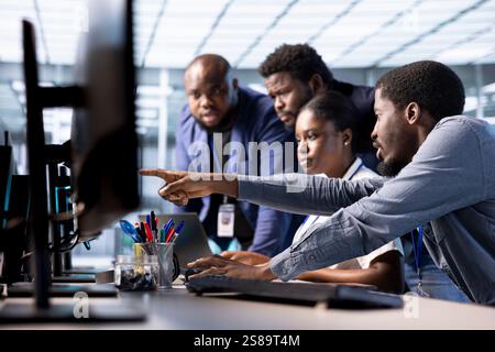 Data center coworkers doing brainstorming, creating technical documentation for software applications. IT colleagues collaborating, working together in server room maintaining databases Stock Photo