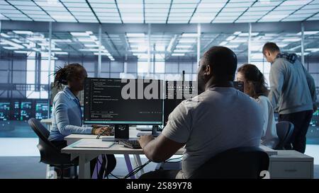 Admin programming in server room housing advanced equipment storing massive datasets. Developer typing code on PC to mend data center racks doing complex computational operations, camera B Stock Photo