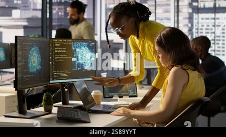Admin and coworker conducting experiments and tests to optimize AI machine learning models for performance and accuracy. Team of IT experts in office analyzing artificial intelligence data, camera A Stock Photo