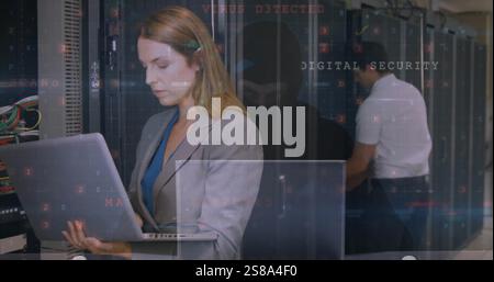 Image of security data processing over diverse colleagues working in server room Stock Photo