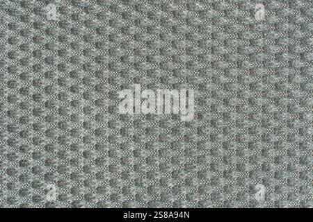 close-up of light neutral gray textured fabric background surface in full frame, raised bumpy grid like pattern abstract Stock Photo
