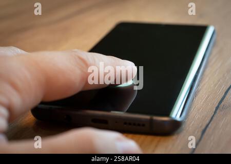 Fingerprint With Personal Verification App. Biometric Identification. Unlocking Smartphone Scanning. male finger presses on the smartphone screen to u Stock Photo