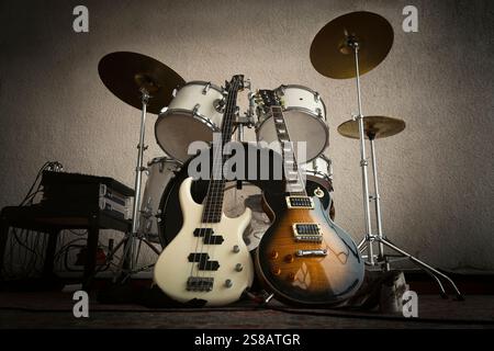 Rock Band, solo guitar, bass, drums in the dark light ready for the gig. Rehearsal base. Recording studio. Rock and roll concept Stock Photo