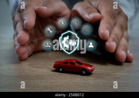 car insurance A hand is protecting a red toy car with a shield on it. warranty concept Stock Photo