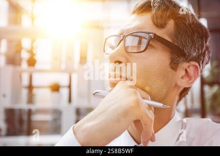 close-up. pensive young businessman in the office looking away. Stock Photo