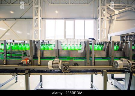 Bottling process in a modern factory with green beverage bottles on a conveyor belt Stock Photo