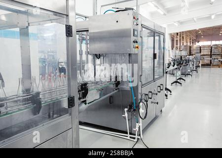 Advanced bottling machine operates in a modern beverage manufacturing facility during daylight hours Stock Photo
