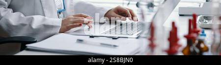 Typing on Laptop While Working in Laboratory Environment Stock Photo