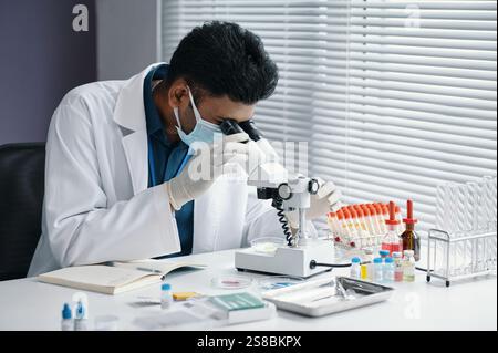 Scientist Analyzing Samples Under Microscope in Laboratory Stock Photo
