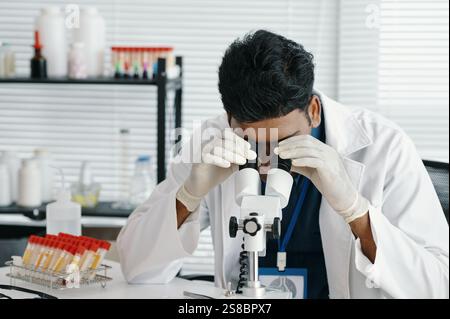 Scientist Examining Sample Through Microscope in Laboratory Stock Photo