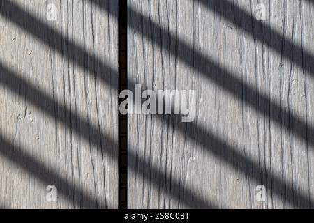 stripe shadow on silver gray deck timber, pattern backgrounds wallpaper surface, contrast modern architecture building construction housing, macro Stock Photo