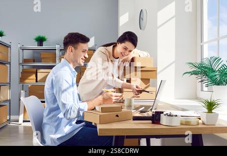 Coworkers Managing Inventory In Online Store Warehouse Using Laptop Stock Photo