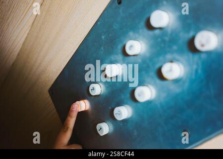 A small child's female hand presses the button in the elevator to go to the ground floor. Detail of the control panel with focus on the finger. Stock Photo