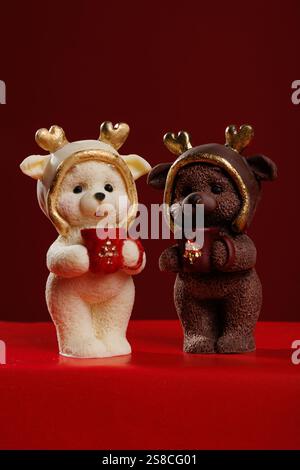 Two Christmas teddy bear figurines on a red background Stock Photo