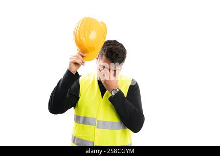 Tired stressed adult constructor man wearing fluorescent vest work equipment touching eyes  migraine gesture isolated on white background Stock Photo