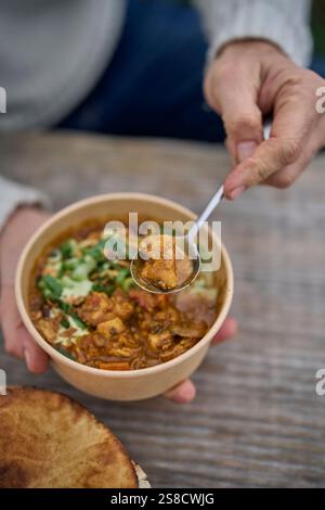 Winter spiced chicken soup and flatbreads cooked over fire at the Hidden Hut cafe at Porthcurnick Beach, Cornwall, UK Stock Photo