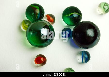 Colourful blue and green glass balls isolated on white background top view. Marble toys. Congkak is a traditional game in Asia. Marbles wallpapers. Stock Photo