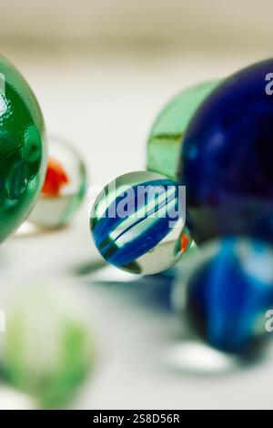 Colourful blue and green glass balls isolated on white background close up. Marble toys. Congkak is a traditional game in Asia. Marbles wallpapers. Stock Photo