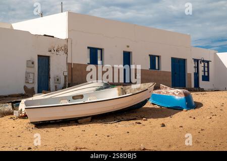 Street covered by sand. White residential house. Blue wooden doors and ...