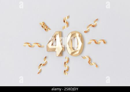 Golden number 40 and ribbons on a blue background. Festive composition. Stock Photo