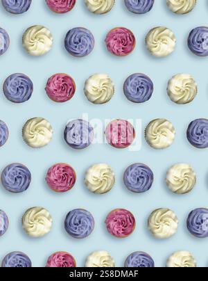 Pattern of cupcakes with cream on light blue background, top view Stock Photo