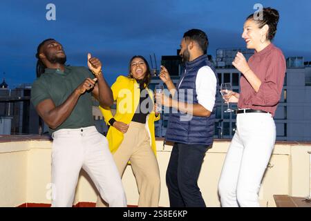 A lively group of friends celebrating at a rooftop party in the city They are dancing, laughing, and enjoying the night with drinks, capturing the spi Stock Photo