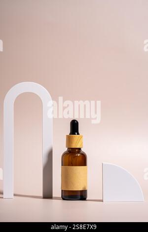 A minimalist setup featuring a brown glass dropper bottle with wooden cap, placed on a beige background accented by white geometric shapes, capturing Stock Photo
