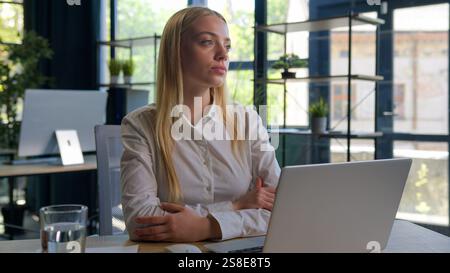 Portrait dreaming Caucasian businesswoman at office desk thoughtful pensive girl thinking deep in thoughts consider plan looking away search solution Stock Photo