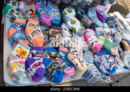 Hand knitted wool baby socks with ornaments. Hand knitted wool baby booties for sale. Background. Stock Photo