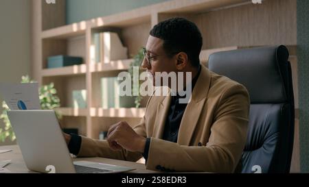 African American businessman entrepreneur office worker agent manager CEO man study business plan strategy male employer typing data online project on Stock Photo