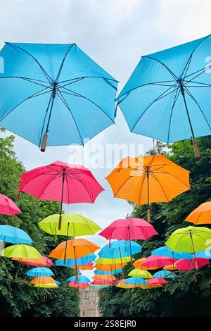Street decorated with colored umbrellas. Colorful umbrellas against sky Stock Photo