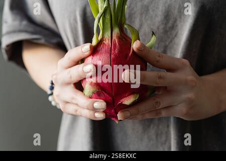 Close-up of female hands holding a vibrant pitahaya fruit. Stock Photo