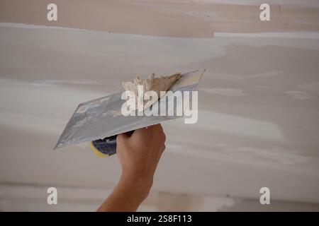man plastering ceiling repair. Selective focus. Stock Photo