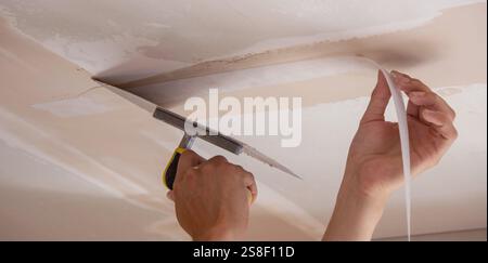 man plastering ceiling repair. Selective focus. Stock Photo