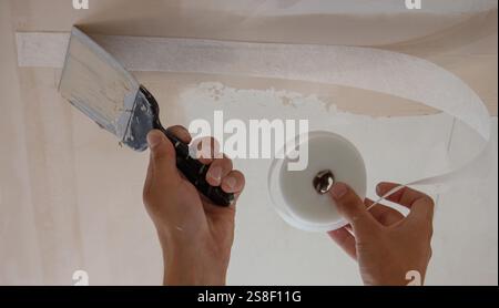 man plastering ceiling repair. Selective focus. Stock Photo