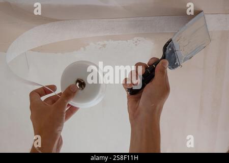 man plastering ceiling repair. Selective focus. Stock Photo