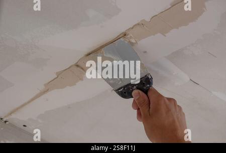 man plastering ceiling repair. Selective focus. Stock Photo